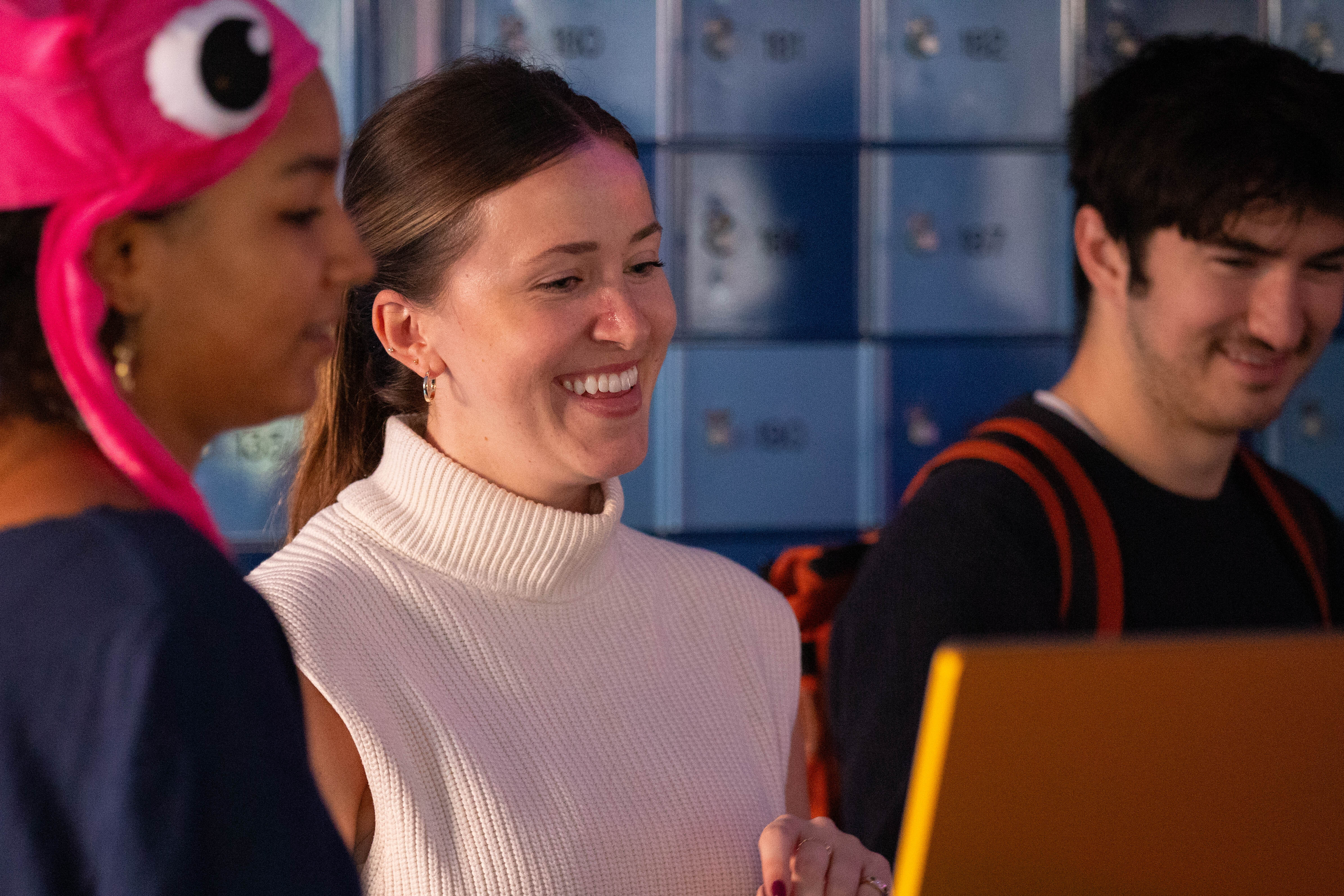 a participant smiling at the screen of station two as a poem is generated from her audio prompt